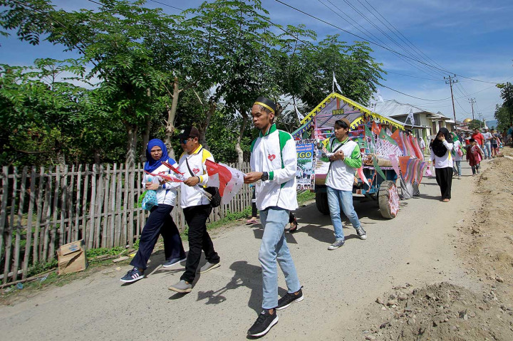 Panitia berkampung dan mendatangi rumah warga untuk membagikan paket kudapan kepada anak-anak di Kabila, Kabupaten Bone Bolango, Gorontalo, Selasa, 20 November. Panitia kegiatan Walima Goroba (Waligo) ke-21 membagikan 1.000 paket kudapan dan bendera untuk merayakan Maulid Nabi Muhammad. Antara Foto/Adiwinata Solihin