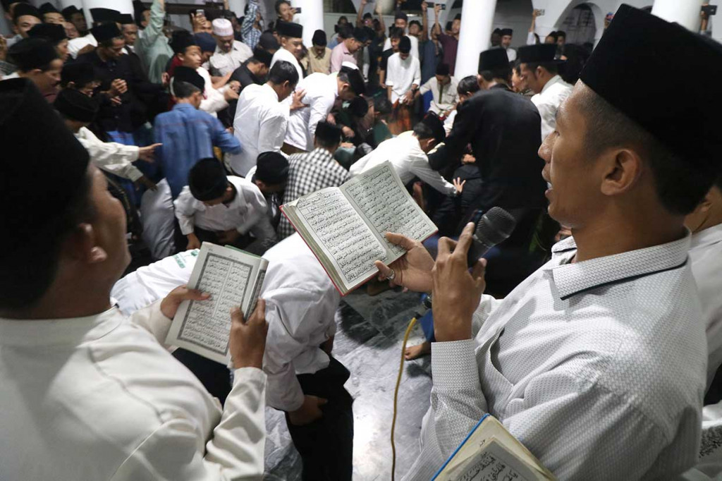 Jemaah membaca sholawat nabi saat tradisi berebut koin pada peringatan Maulid Nabi Muhammad SAW di Masjid Jami Jamsaren, Kota Kediri, Jawa Timur, Senin, 19 November malam. Antara Foto/Prasetia Fauzani