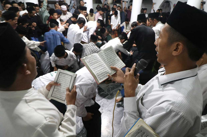 Jemaah membaca sholawat nabi saat tradisi berebut koin pada peringatan Maulid Nabi Muhammad SAW di Masjid Jami Jamsaren, Kota Kediri, Jawa Timur, Senin, 19 November malam. Antara Foto/Prasetia Fauzani