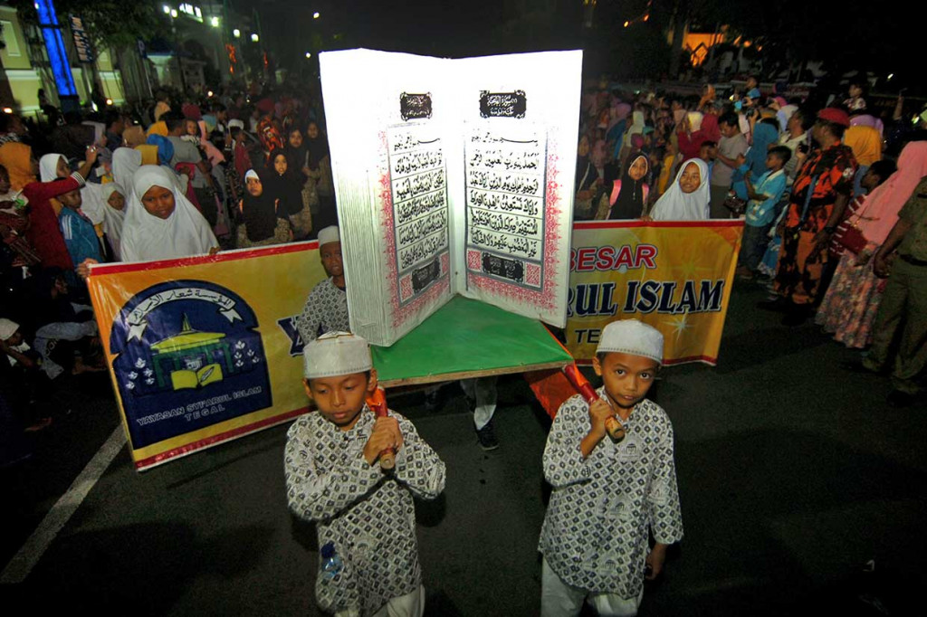 Sejumlah peserta menggotong Al'Quran raksasa saat pawai Rolasan saat memperingati Maulid Nabi Muhammad SAW di Tegal, Jawa Tengah, Senin, 19 November malam. Antara Foto/Oky Lukmansyah
