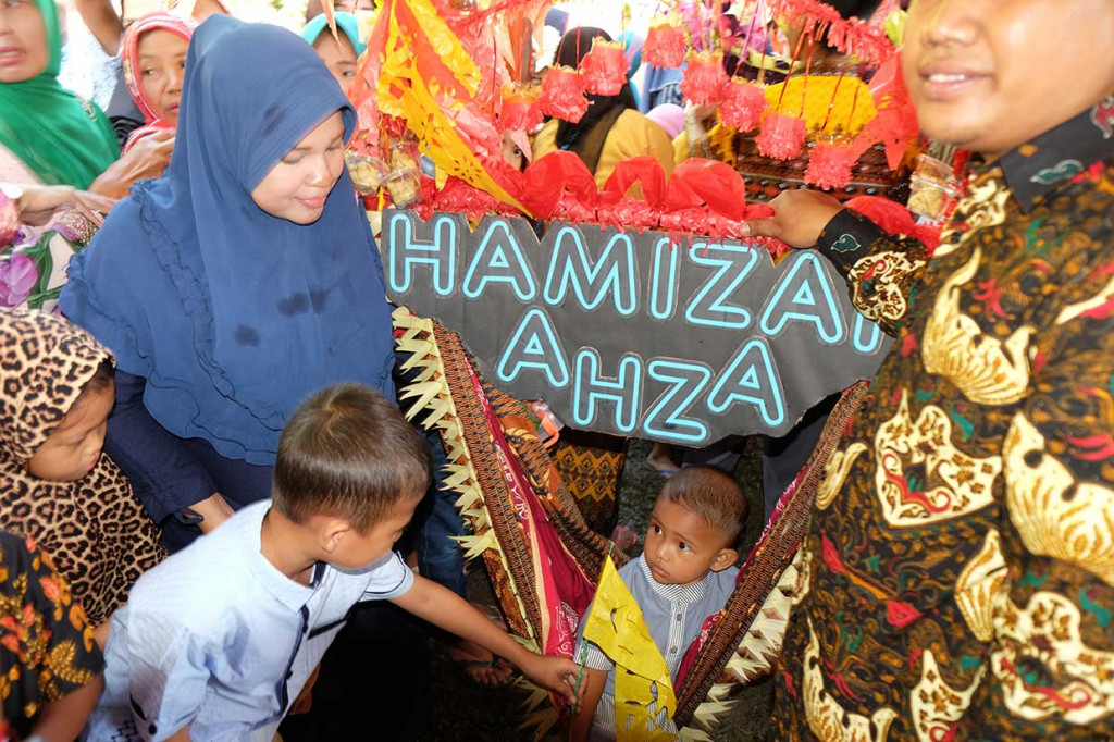 Seorang balita bersama orangtuanya mengikuti prosesi Baayun Maulud di Kecamatan Hamparan Perak, Deli Serdang, Sumatera Utara, Selasa, 20 November 2018. 