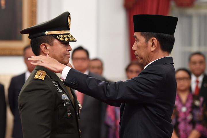 Presiden Joko Widodo (kanan) memasangkan tanda pangkat jabatan kepundak Kepala Staf Angkatan Darat (KSAD) yang baru Jenderal TNI Andika Perkasa (kiri) seusai pelantikan di Istana Merdeka, Jakarta.