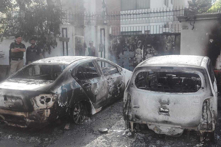 Personil keamanan Pakistan berjaga-jaga di dekat kendaraan yang hangus terbakar pascapenyerbuan sekelompok pria bersenjata di depan Konsulat Tiongkok di Karachi, Jumat, 23 November 2018.