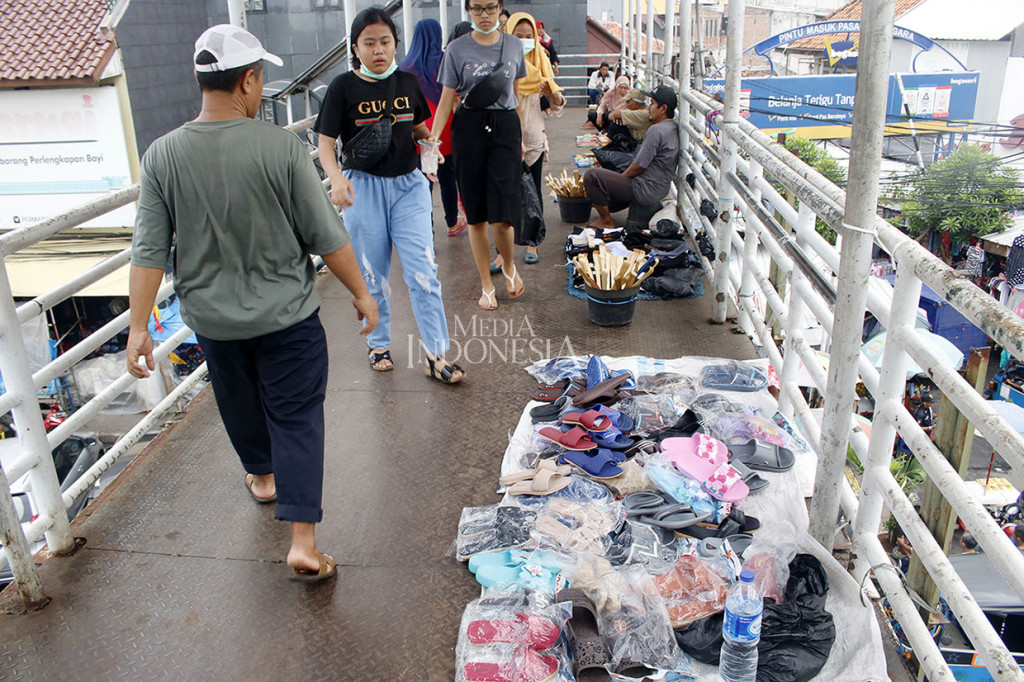 Warga berjalan di jembatan penyeberangan orang (JPO) Pasar Jatinegara, Jakarta Timur yang dipenuhi pedagang kaki lima (PKL), Sabtu, 24 November 2018.