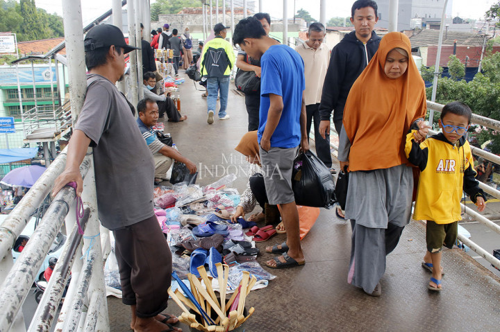 PKL menggelar lapaknya memakan hampir separuh ruas jalan JPO yang membuat para pejalan kaki terganggu.