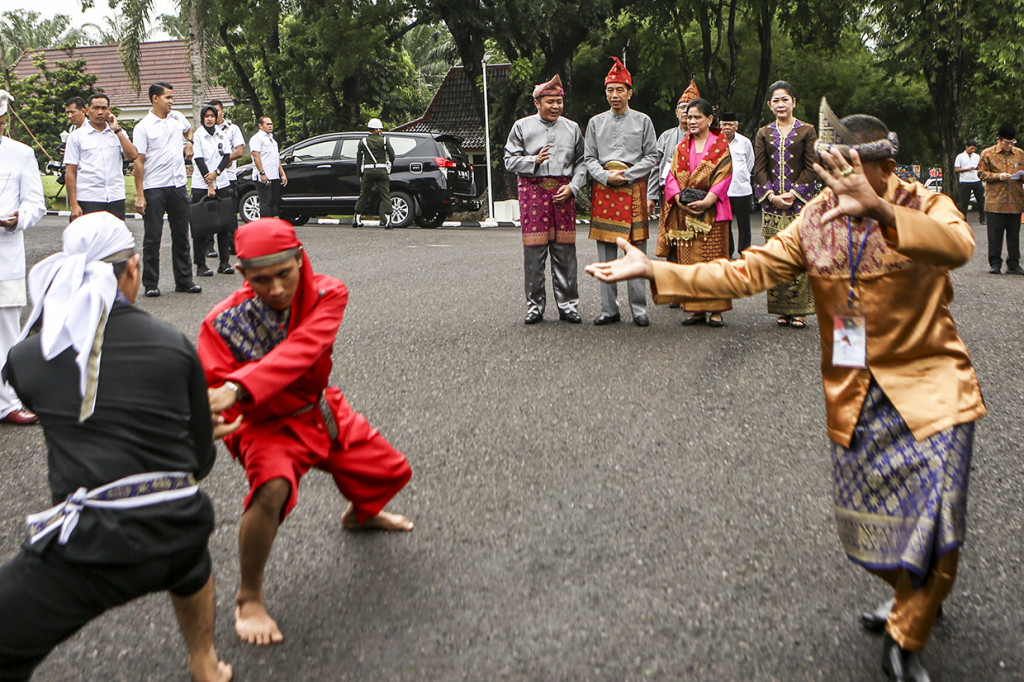 Presiden Joko Widodo (kedua kiri belakang) didampingi Ibu Negara Iriana Joko Widodo (kedua kanan belakang) didampingi Gubernur Sumatera Selatan Herman Deru (kiri belakang) dan istri Febrita Lustia (kanan belakang) menyaksikan atraksi pencak silat saat menghadiri penganugerahan gelar kehormatan adat Komering Provinsi Sumatera Selatan di halaman Griya Agung Palembang, Sumatera Selatan.