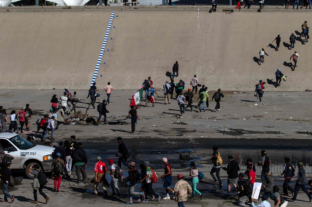 Mereka bergerak mendekati Perlindungan Perbatasan dan Bea Cukai AS yang kini didukung personel kepolisian militer. Afp Photo/Guileermo Arias