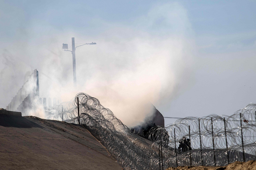 Perlindungan Perbatasan dan Bea Cukai AS menyebut para imigran melemparkan sejumlah proyektil kepada mereka. Sebagai respons, para petugas penjaga perbatasan AS itu menembakkan sejumlah besar gas air mata. Afp Photo/Guileermo Arias