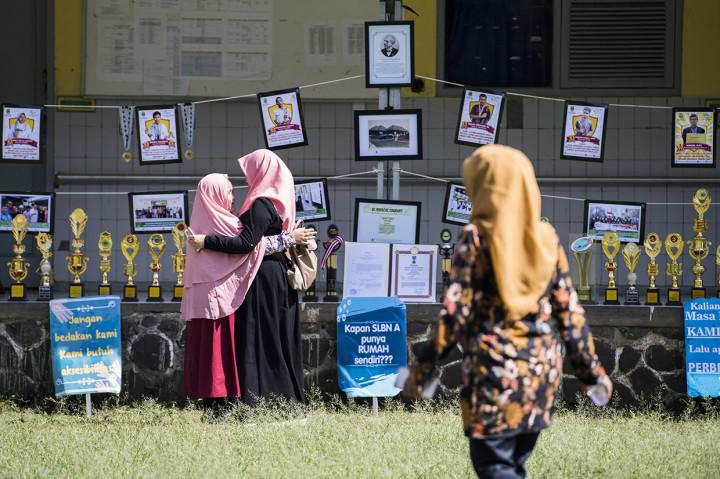 Seorang siswa memeluk orangtuanya di sela-sela kegiatan menulis surat untuk presiden dengan huruf braille di Sekolah Luar Biasa Negeri (SLBN) A, Bandung, Jawa Barat.
