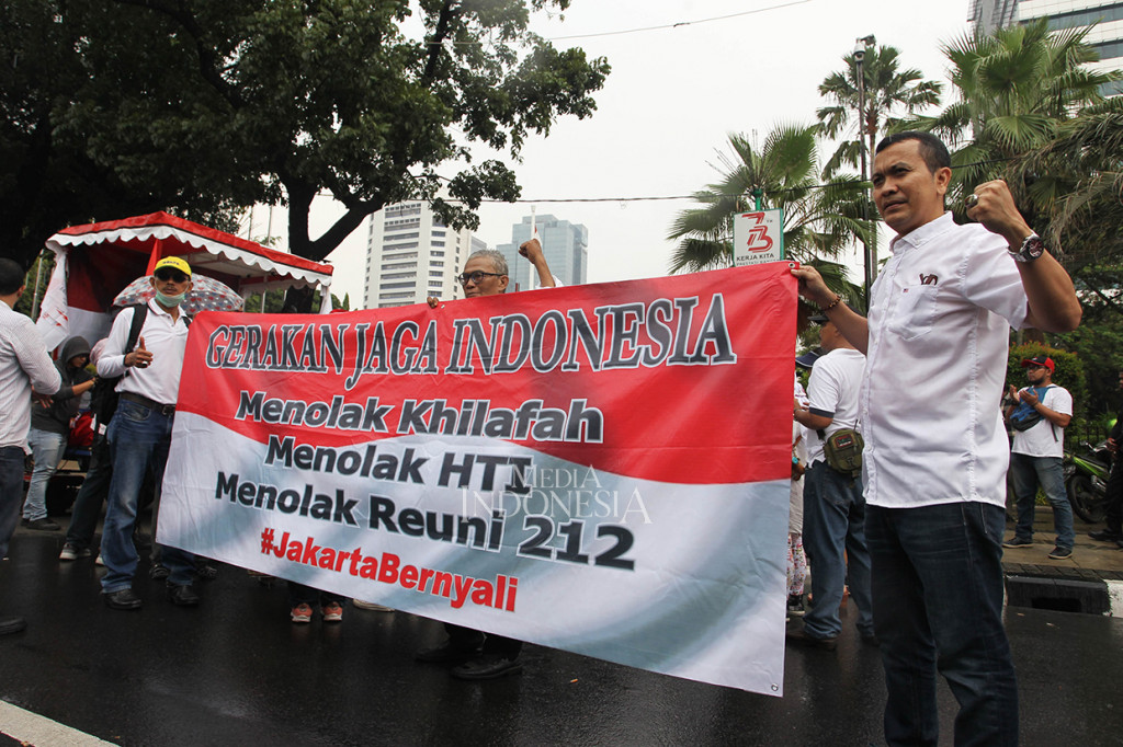 Massa membawa spanduk bertuliskan 