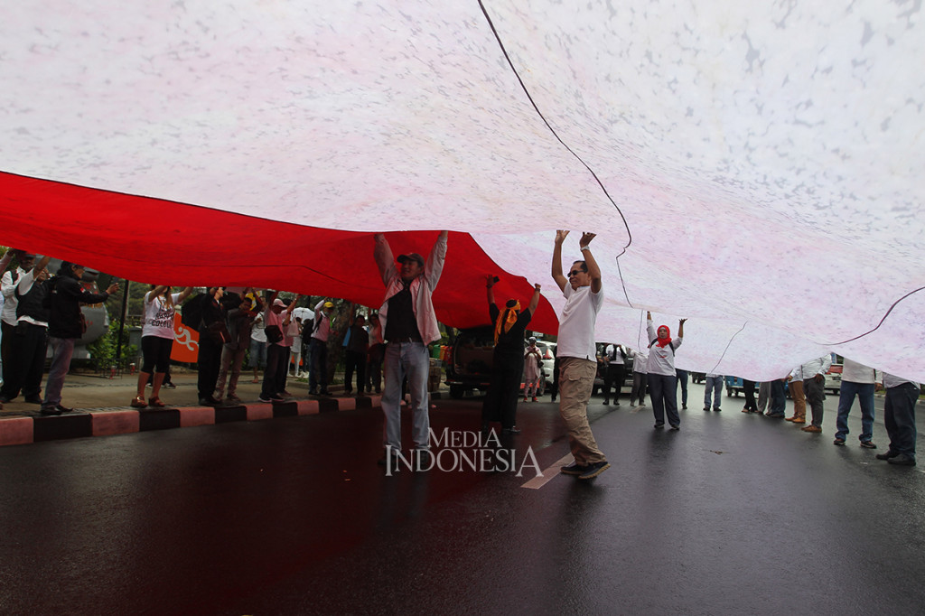 Sejumlah massa yang tergabung dalam Gerakan Jangan Ganggu Indonesia melakukan aksi membentangkan bendera merah putih di depan Balai Kota Jakarta.