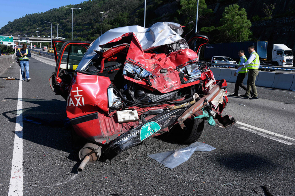 Kondisi taksi usai ditabrak bus di Hong Kong. Bagian belakang taksi ringsek parah akibat tabrakan ini.
