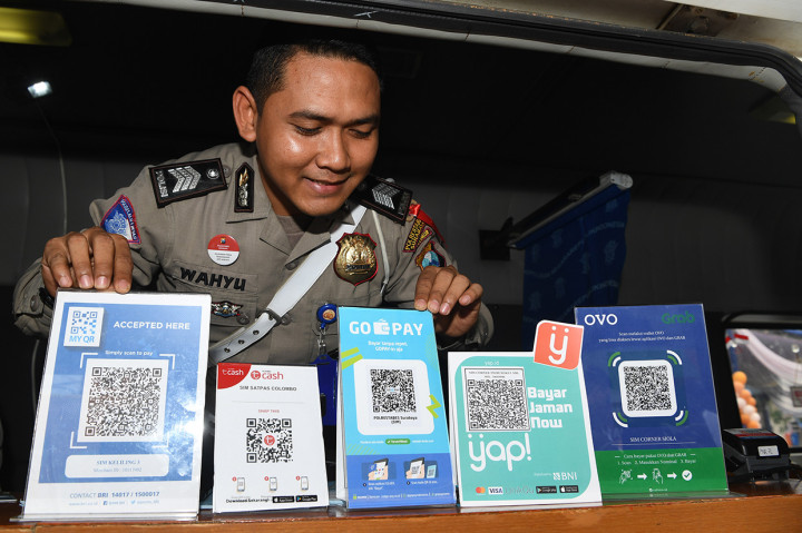 Polisi menunjukkan sejumlah layanan QR code yang terdapat di pelayanan SIM Keliling disela-sela peluncuran program 'Cashless Payment PNBP SIM dan SKCK di Polrestabes Surabaya. Dengan adanya layanan pembayaran nontunai tersebut diharapkan masyarakat dimudahkan dalam melakukan transaksi saat membayar PNBP SIM dan SKCK di Polrestabes Surabaya.