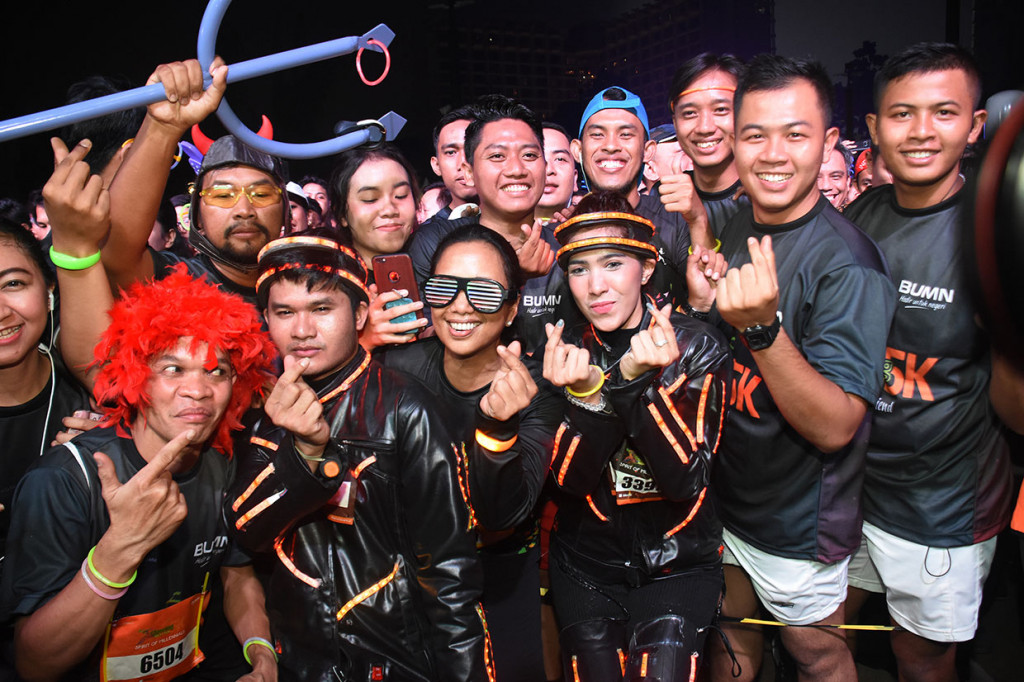 Menteri BUMN Rini M Soemarno (tengah) berfoto bersama para peserta lari di depan garis start pada acara Glowing Night Run 5K di Parkir Timur Senayan, Gelora Bung Karno (GBK), Jakarta.