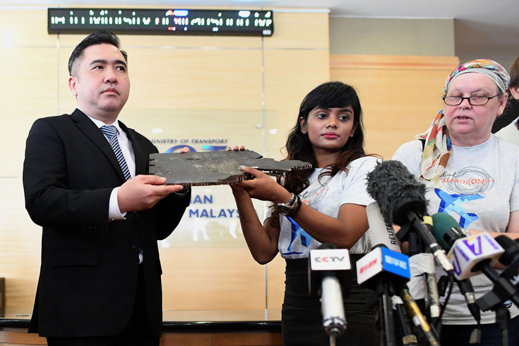 Grace Subathirai Nathan (kanan), putri salah satu penumpang pesawat Malaysia Airlines MH370, menyerahkan puing-puing yang diyakini berasal dari pesawat MH370 ke Menteri Transportasi Malaysia Anthony Loke di Putrajaya, Jumat, 30 November 2018.