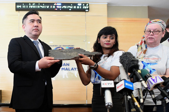 Grace Subathirai Nathan (kanan), putri salah satu penumpang pesawat Malaysia Airlines MH370, menyerahkan puing-puing yang diyakini berasal dari pesawat MH370 ke Menteri Transportasi Malaysia Anthony Loke di Putrajaya, Jumat, 30 November 2018.