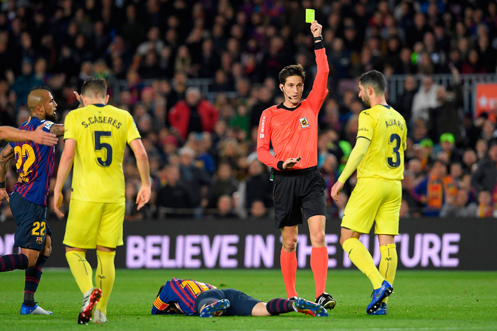 Pemain belakang Villarreal Alvaro Gonzalez diganjar kartu kuning karena melanggar Lionel Messi.
