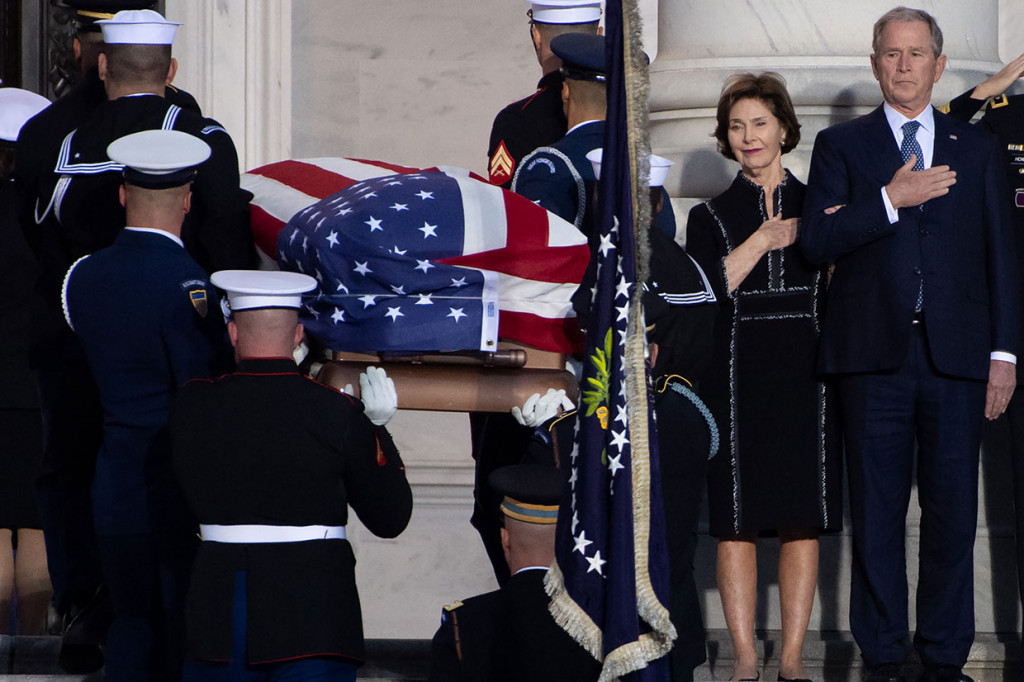 Keluarga Bush, dipimpin puteranya yang juga mantan Presiden George W. Bush, menyertai jasad kepala keluarga itu --yang dibawa dengan pesawat kepresidenan Air Force One dari Texas menuju Pangkalan Gabungan Andrews di luar Washington, dan kemudian melintasi Pennsylvania Avenue menuju Kapitol.