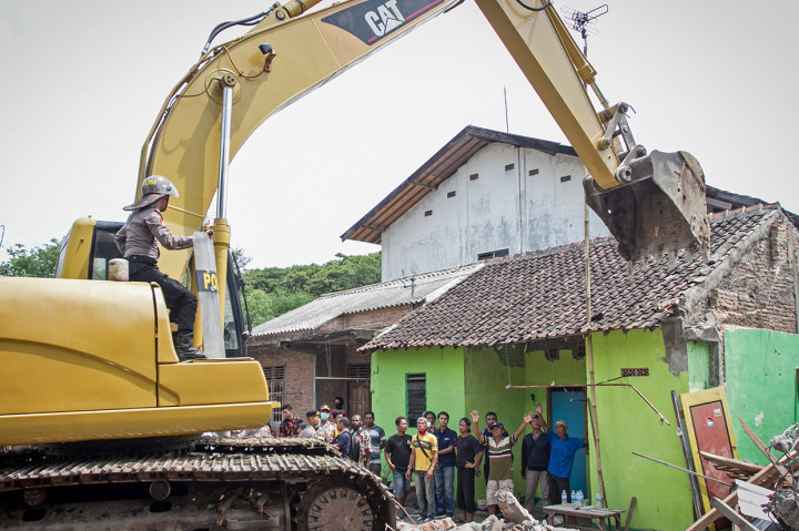 Sejumlah warga berusaha mengahalangi alat berat merubuhkan sebuah rumah saat proses eksekusi lahan di Kentingan Baru, Solo.