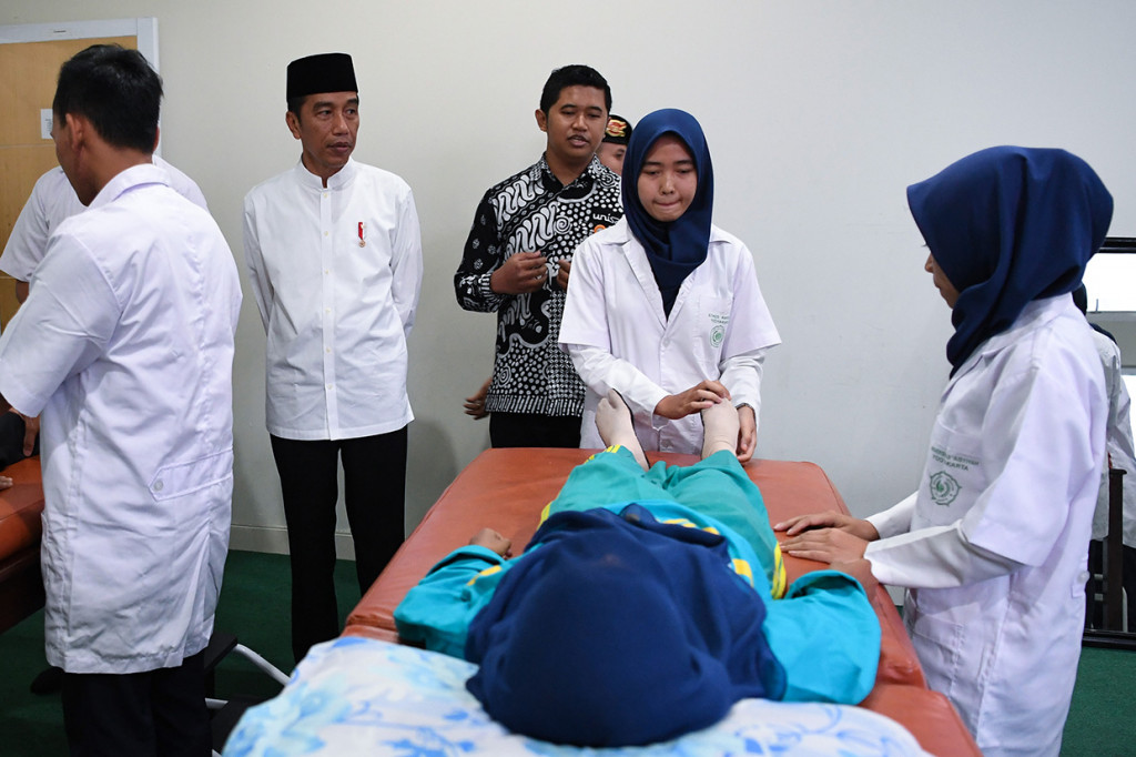 Presiden Joko Widodo mengamati mahasiswa yang melakukan pelatihan penanganan pasien saat mengunjungi Universitas Aisyiyah di Yogyakarta.