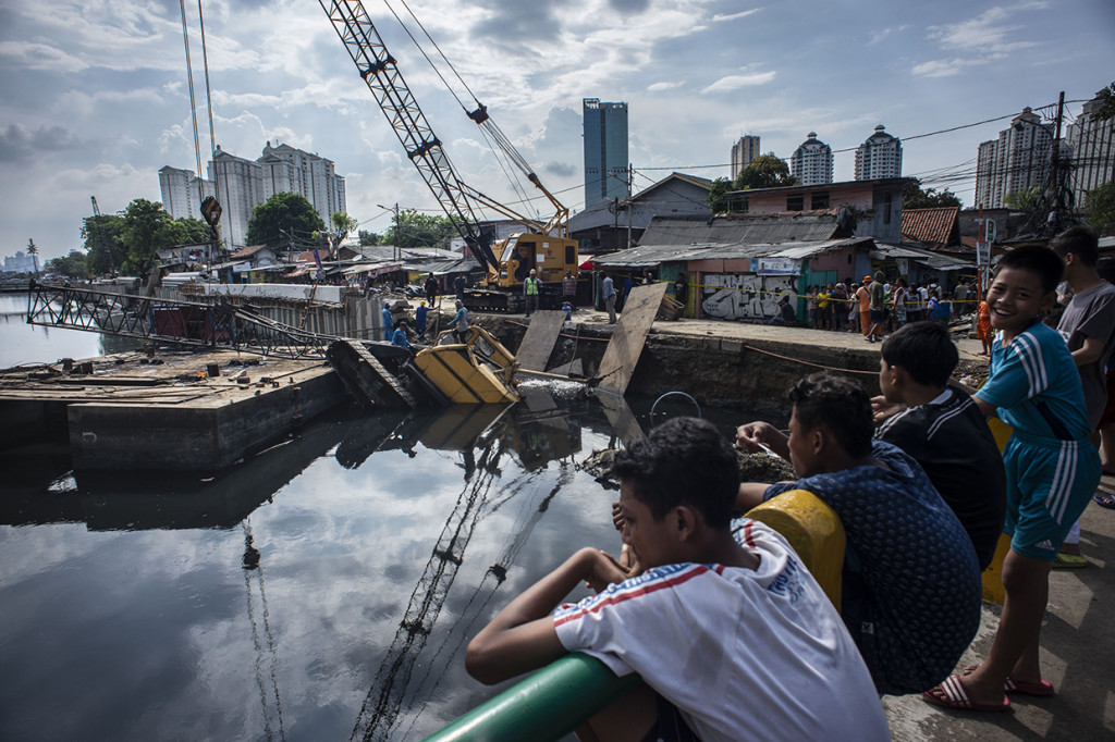 Crane dari proyek pemasangan dinding turap Kali Sentiong ambruk dan menimpa rumah warga sehingga menyebabkan tiga orang terluka.