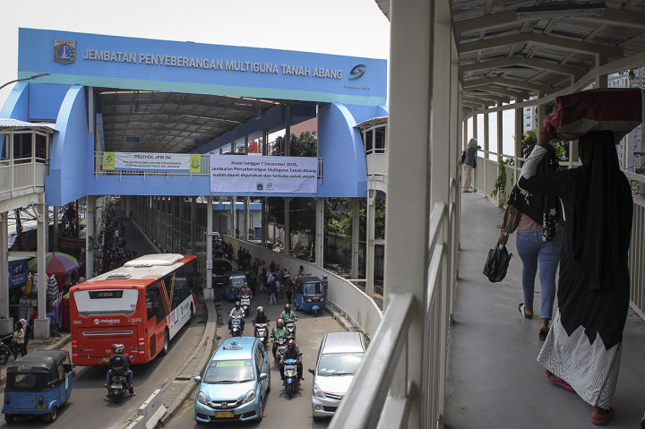 Pejalan kaki melintasi Skybridge atau Jembatan Penyeberangan Multiguna (JPM) Tanah Abang di Jakarta.