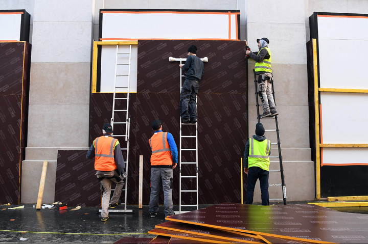 Seorang pekerja memasang papan kayu untuk melindungi jendela di sebuah toko di kawasanChamps-Elysees, Paris. Afp Photo/Alain Jocard
