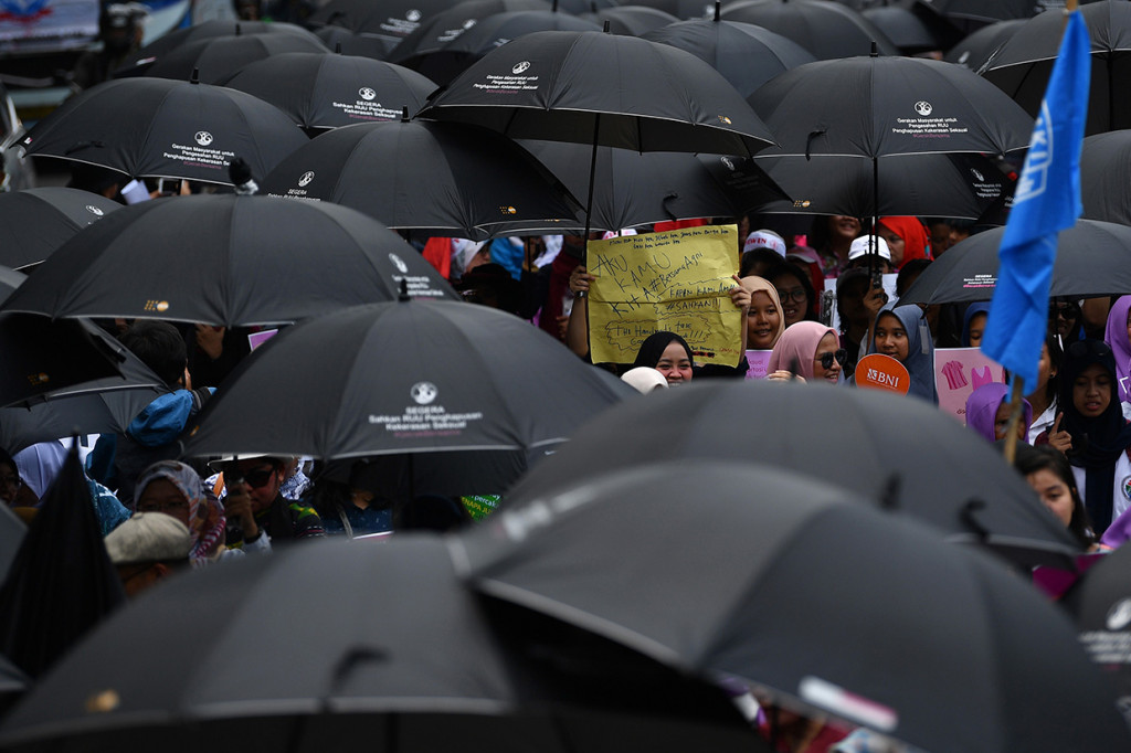 Mereka memakai payung hitam sebagai ketidakpedulian pemerintah dan DPR karena stagnansi pembahasan RUU tersebut.