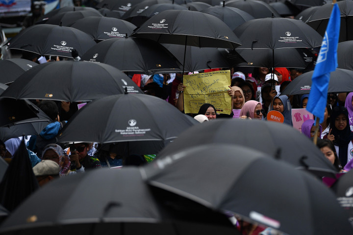 Mereka memakai payung hitam sebagai ketidakpedulian pemerintah dan DPR karena stagnansi pembahasan RUU tersebut.