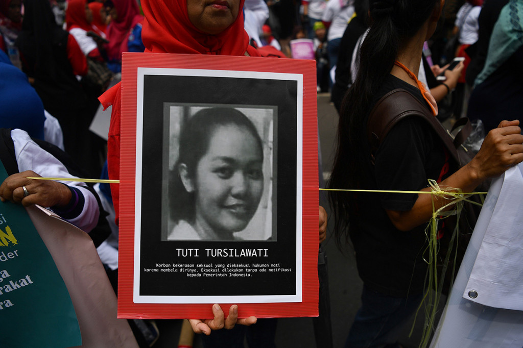 Massa membawa poster Tuti Tursilawati, TKI yang dieksekusi mati di Arab Saudi.
