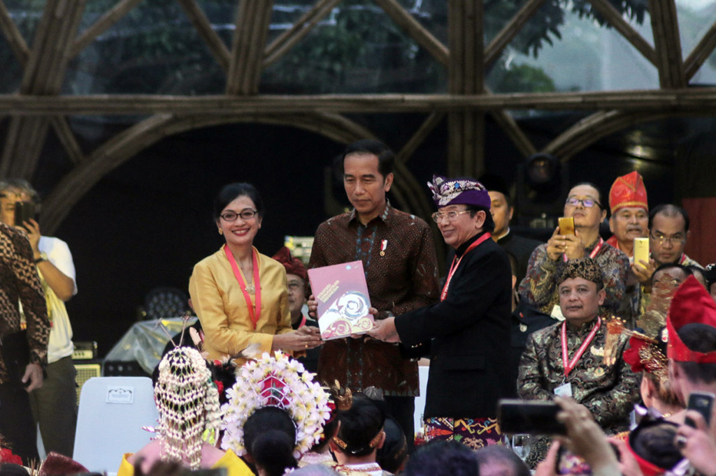 Presiden Joko Widodo (tengah) menerima strategi kebudayaan yang diserahkan Aktris Nungki Kusumastuti (kiri) dan Budayawan I Made Bandem pada Kongres Kebudayaan Indonesia 2018 di Jakarta, Minggu, 9 Desember 2018.