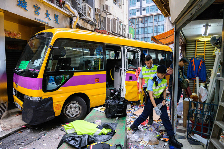 Polisi melakukan penyelidikan di lokasi kecelakaan sebuah bus sekolah tanpa sopir yang menabrak para pejalan kaki di North Point, Hong Kong, Senin, 10 Desember 2018.