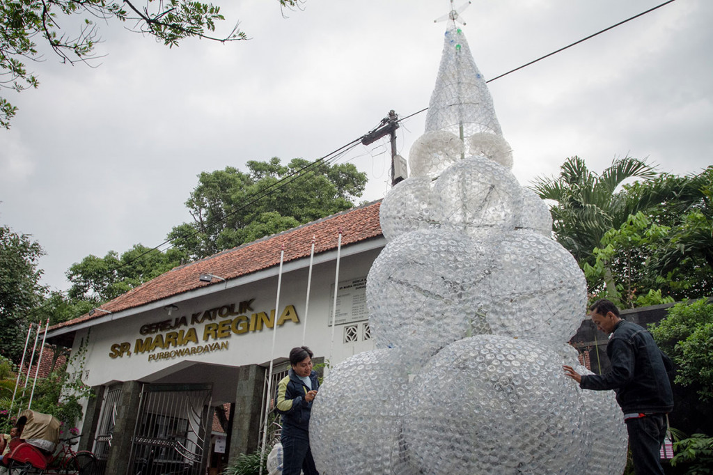 Jemaat tengah membuat pohon natal dari limbah botol plastik di Gereja Maria Regina Purbowardayan, Solo, Jawa Tengah, Senin, 10 Desember 2018. 