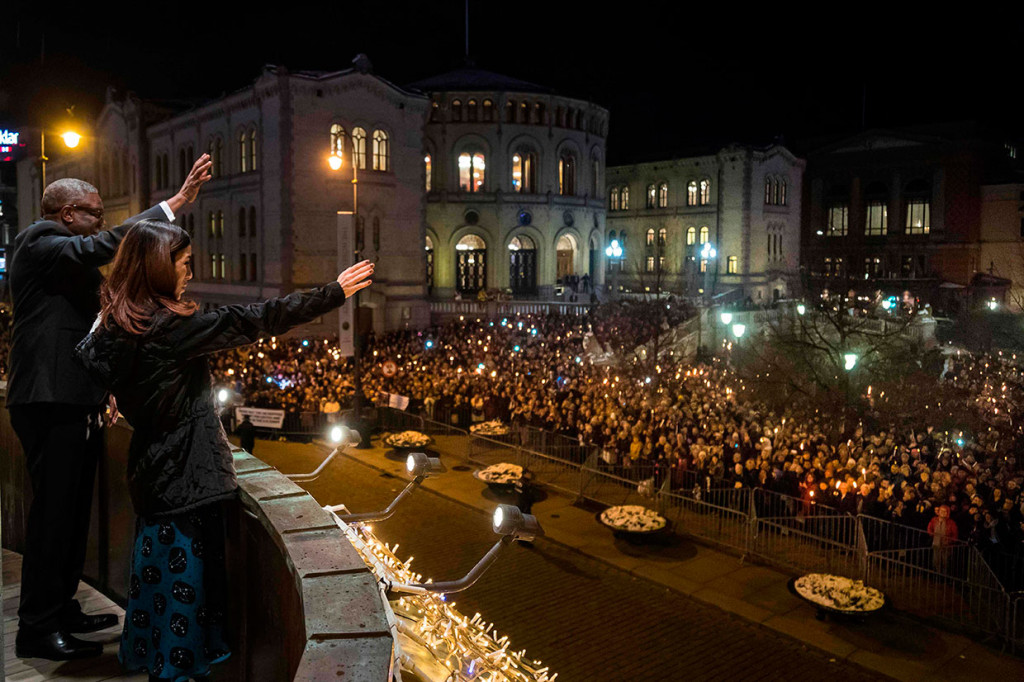 Murad dan Mukwege melambaikan tangan kepada orang-orang yang memegang lilin selama prosesi penyerahan Nobel Perdamaian di pusat kota Oslo, Norwegia.