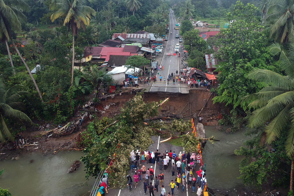 Puluhan warga menyaksikan jembatan yang roboh di jalan raya Padang - Bukittinggi, Kayu Tanam, Kabupaten Padangpariaman, Sumatera Barat, Selasa, 11 Desember 2018.