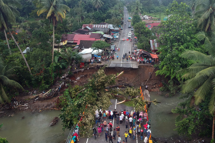 Puluhan warga menyaksikan jembatan yang roboh di jalan raya Padang - Bukittinggi, Kayu Tanam, Kabupaten Padangpariaman, Sumatera Barat, Selasa, 11 Desember 2018.