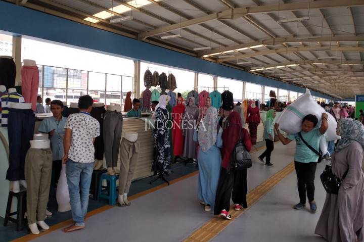 Beberapa pedagang terlihat sibuk membawa barang dagangan serta patung manekin untuk diletakkan di kios baru mereka di skybridge yang telah diujicobakan pada 7 Desember 2018 itu.