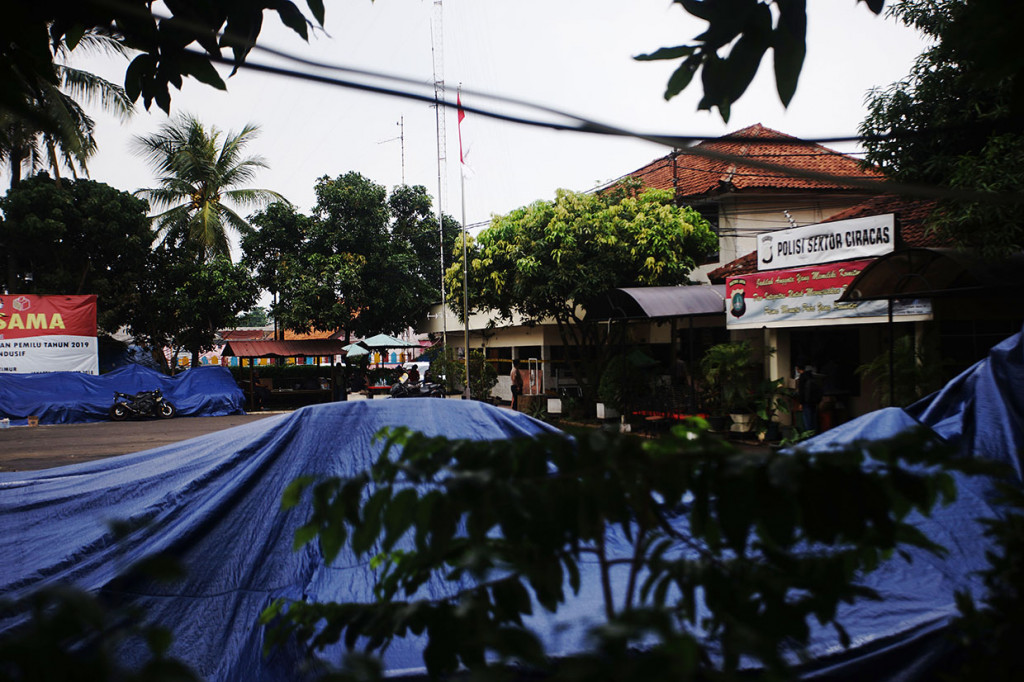 Sejumlah kendaraan ditutupi terpal seusai perusakan dan pembakaran Polsek Ciracas oleh massa di Jalan Raya Bogor, Ciracas, Jakarta Timur.