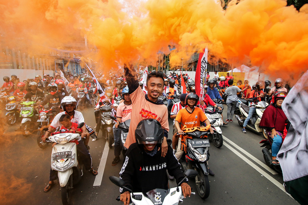 Suporter klub sepakbola Persija Jakarta mengikuti konvoi Penyerahan Piala Gojek Traveloka Liga 1 di Jalan Jenderal Sudirman, Jakarta. Antara Foto/Rivan Awal Lingga
