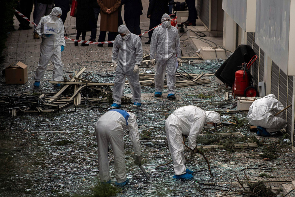 Ahli forensik mencari bukti-bukti pascaterjadinya ledakan bom di luar gedung Skai TV Yunani, di Athena, Senin, 17 Desember 2018.