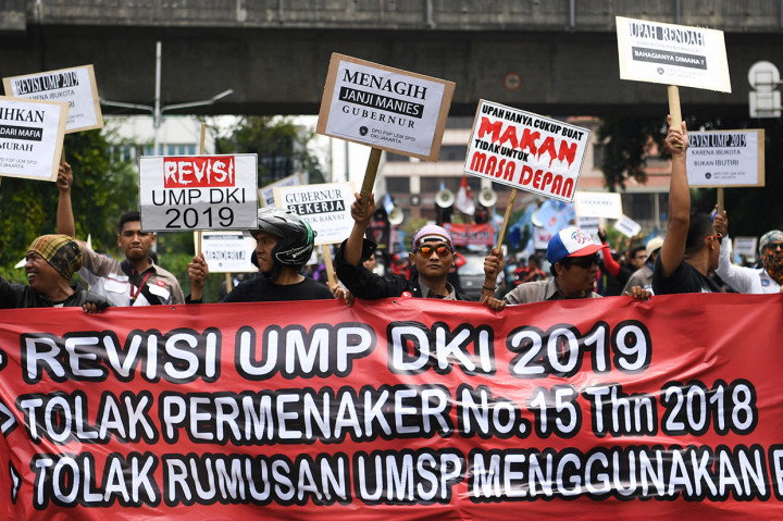 Massa dari berbagai elemen buruh berjalan kaki menuju Balai Kota Jakarta, Selasa, 18 Desember 2018.