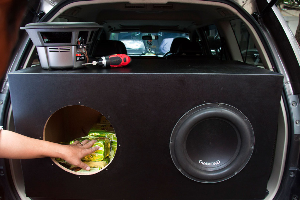 Petugas kepolisian melakukan reka adegan saat menemukan barang bukti sabu dalam speaker mobil, saat rilis kasus penyelundupan narkotika jenis sabu-sabu dan ekstasi jaringan internasional di Polda Metro Jaya, Jakarta.