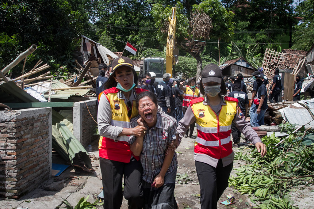 Petugas Kepolisian menenangkan warga yang menangis saat dilakukan eksekusi lahan permukiman warga di Kentingan Baru, Solo, Jawa Tengah, Rabu, 19 Desember 2018.