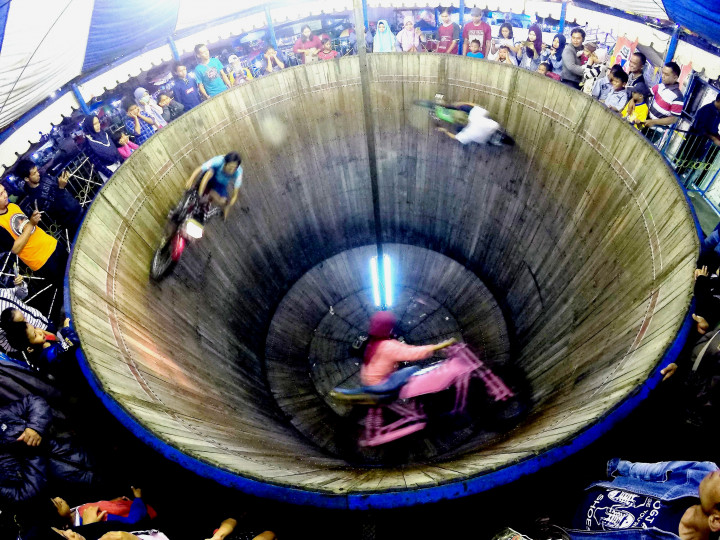 Show time... Devi yang mengendari sepeda motor warna merah muda belajar menjadi joki tong setan dari sang suaminya, Ahmad Herdiansyah Daulay (21). 