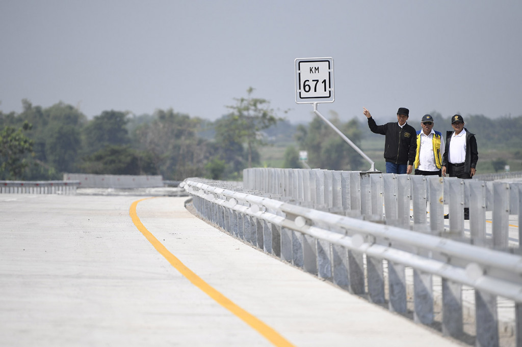 Presiden Joko Widodo (kiri) didampingi Menteri PUPR Basuki Hadimuljono (tengah) dan Seskab Pramono Anung (kanan) meninjau ruas jalan Trans Jawa di Interchange Bandar kilometer 671, Jombang, Jawa Timur.