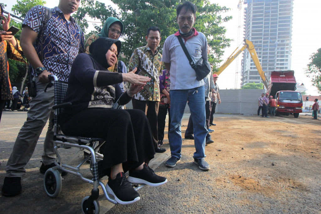 Walkot Tri Risma harus berkursi roda akibat pergelangan kakinya terkilir. “Ini masih sakit. Tapi kalau nggak gini (turun ke lapangan -red) ya nggak cepet-cepet pengerjaannya,