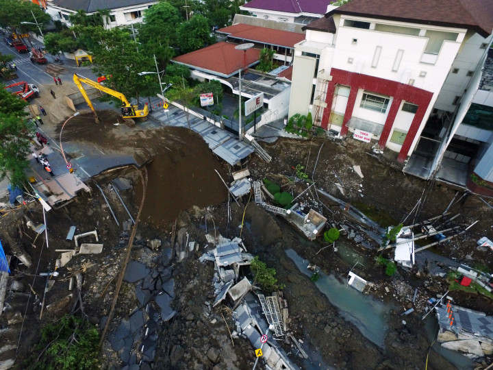 Kegiatan pengurukan di lokasi ruas jalan yang ambles. Dua alat berat Dinas Pekerjaan Umum Bina Marga dan Pematusan Kota Surabaya menguruknya dengan pasir, tanah dan batu. 