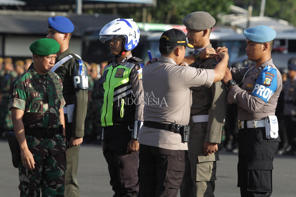 Wakapolda Metro Jaya Brigjen Wahyu Hadiningrat (ketiga kanan) didampingi Kasdam Jaya Brigjen Suharyanto menyematkan pita, saat apel Operasi Lilin Jaya 2018 di Polda Metro Jaya, Jakarta, Jumat, 21 Desember 2018. 
