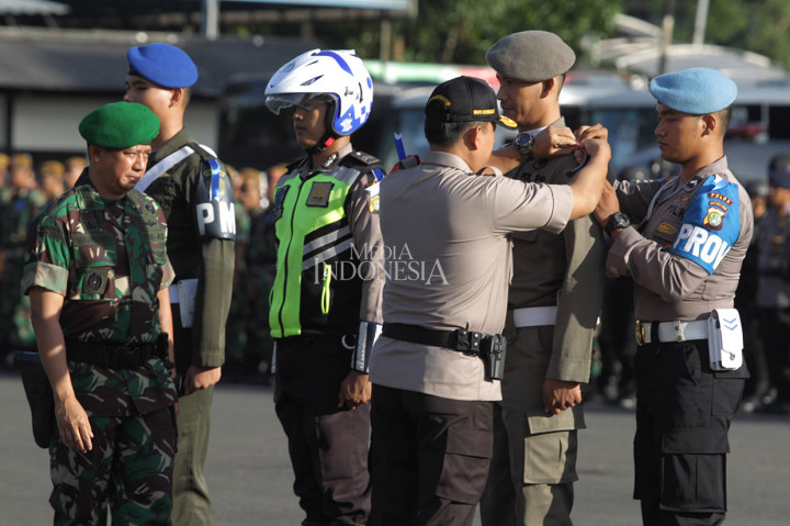 Wakapolda Metro Jaya Brigjen Wahyu Hadiningrat (ketiga kanan) didampingi Kasdam Jaya Brigjen Suharyanto menyematkan pita, saat apel Operasi Lilin Jaya 2018 di Polda Metro Jaya, Jakarta, Jumat, 21 Desember 2018. 