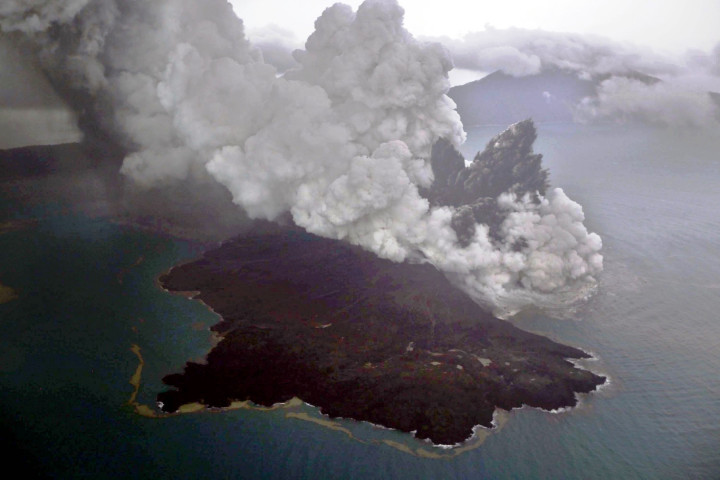 Gunung Kraakatau nampak di balik 'anaknya' yang sedang erupsi. Keduanya adalah gunung berapi aktif yang sebagian besar badannya berada di bawah permukaan laut.